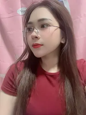 Helen, graceful KL escort girl with sleek ponytail in a silky wrap dress, smiling gently on wood flooring – PinkTitik